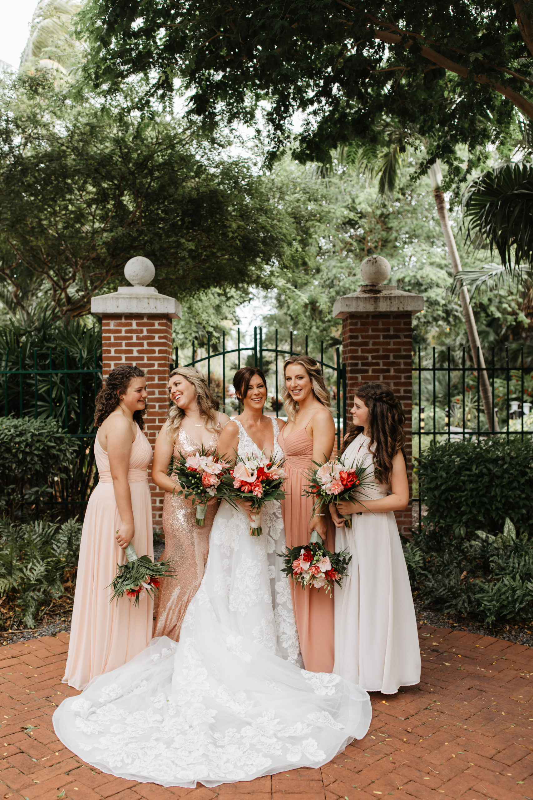 the bridal party standing in front of a fence