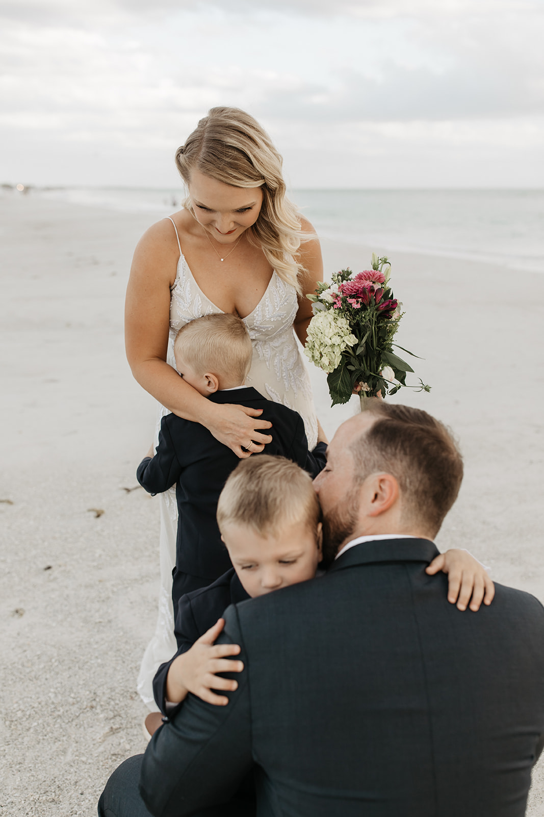 the bride and groom hug the children at their elopement