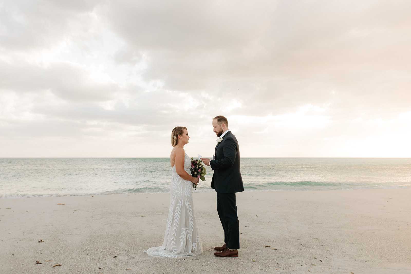 The bride and groom standing on the beach at Anna Maria Island in Florida