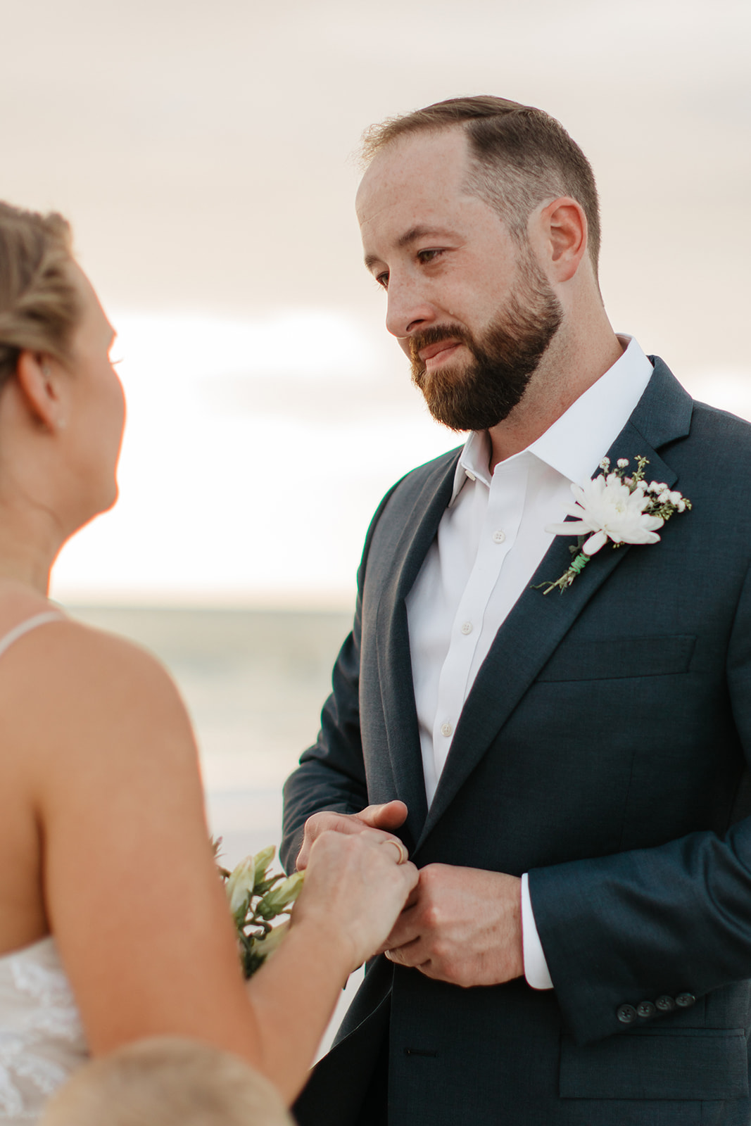 the groom looks into the eyes of his bride at their beach elopement