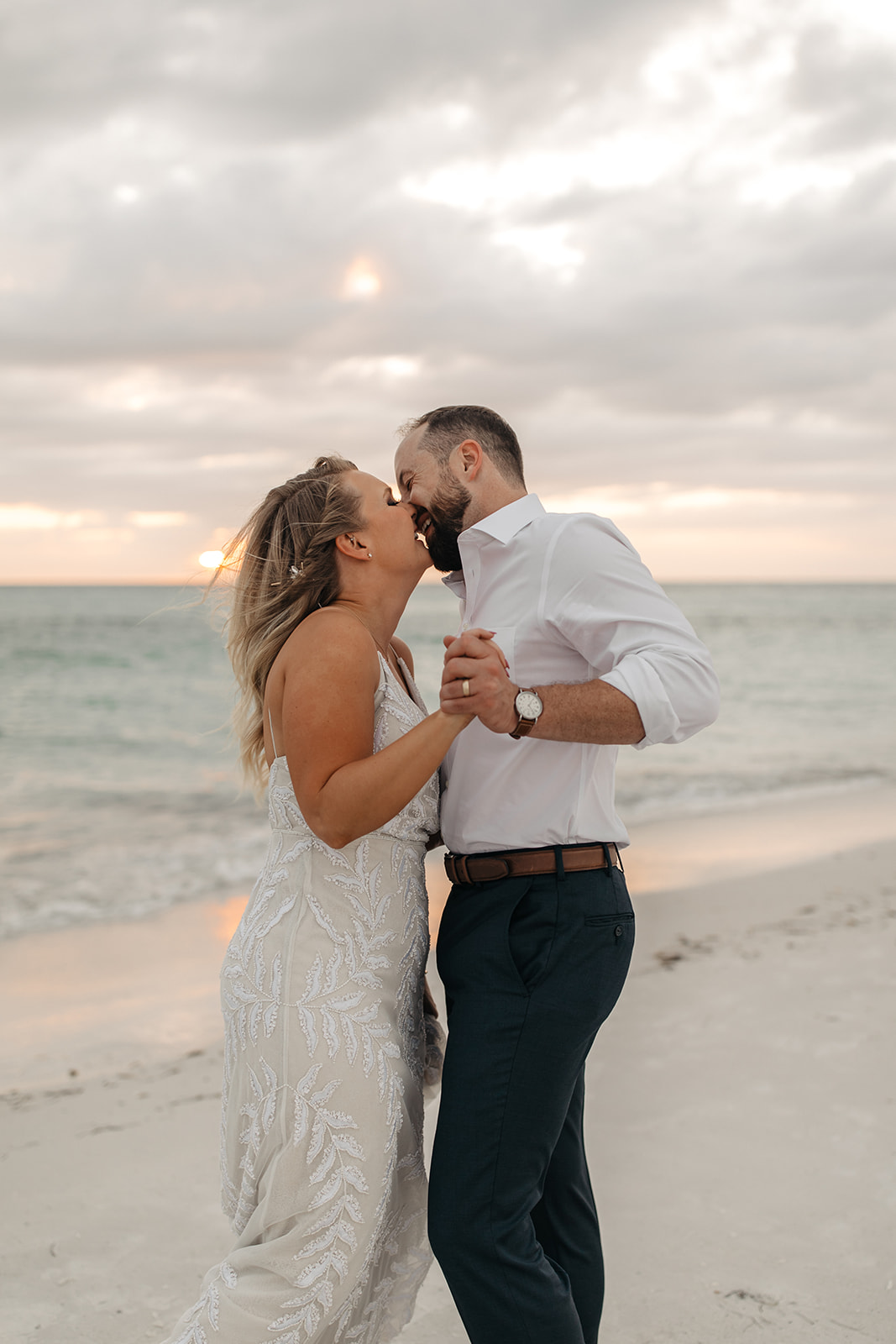 The bride and groom sway together at their beach elopement