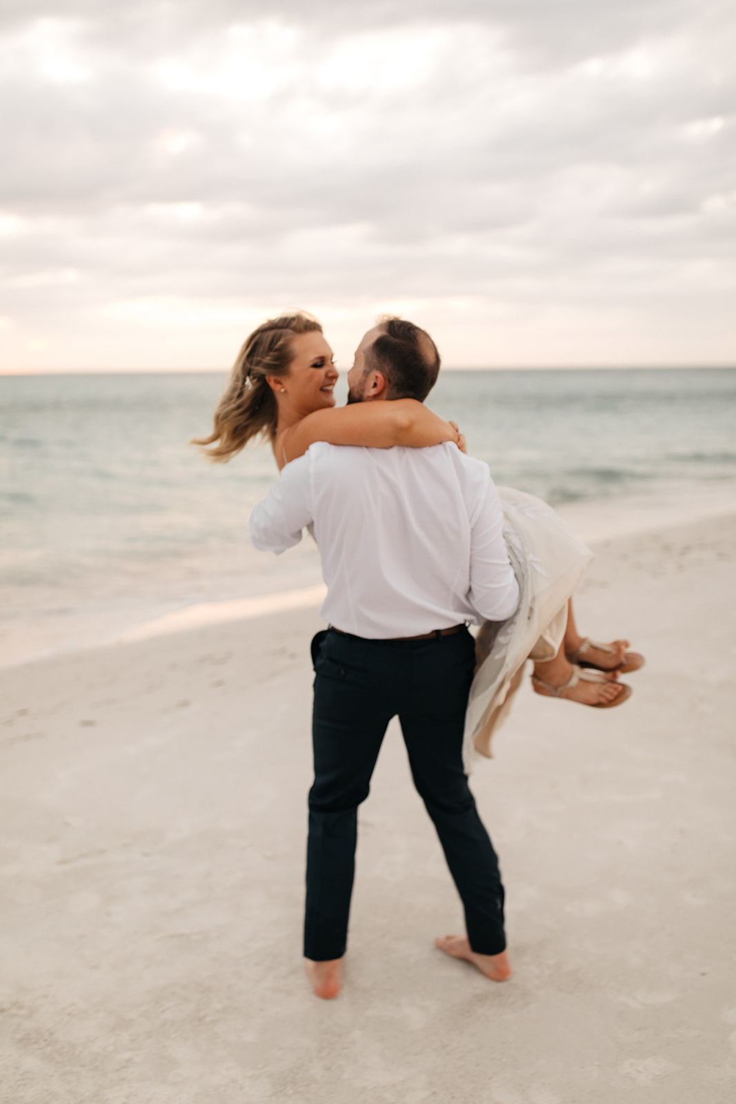the groom twirls his bride at Anna Maria Island in Florida