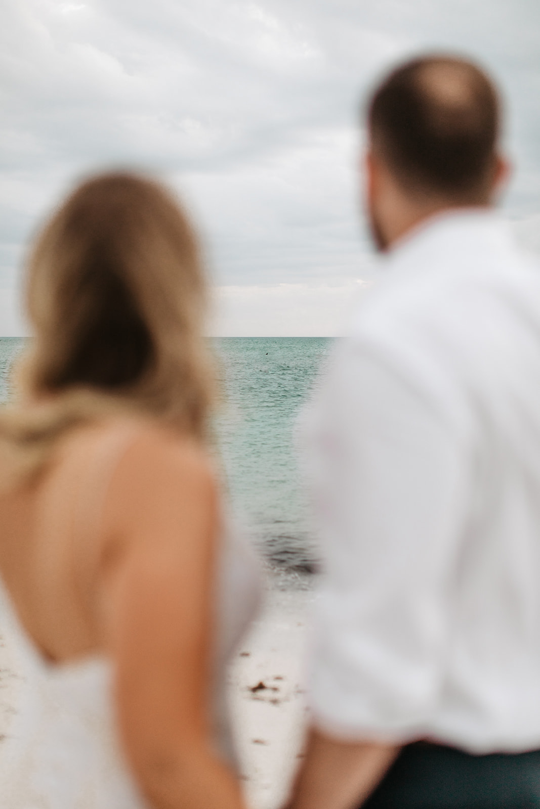 the couple looking at the ocean during their beach elopement