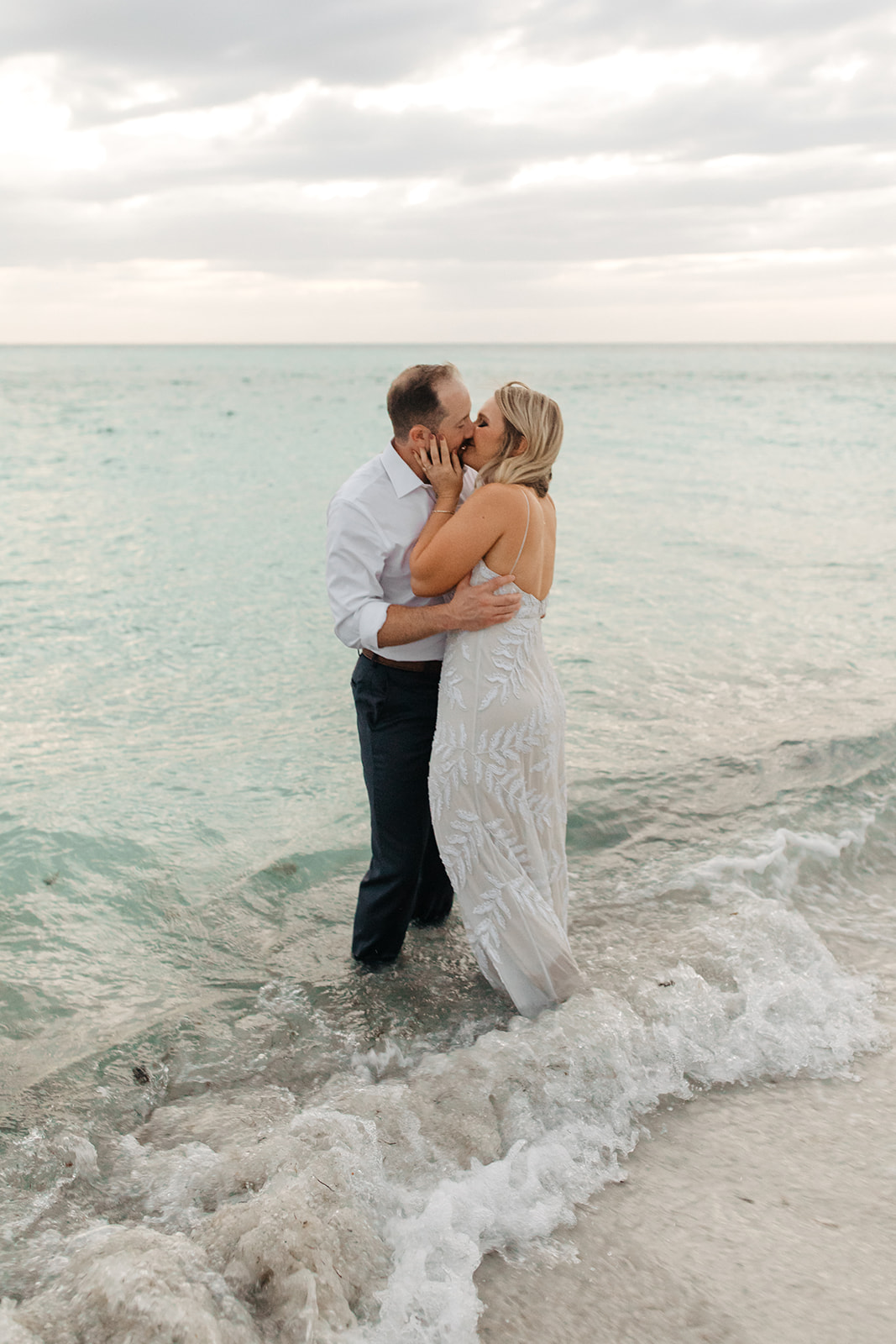 the bride and groom kissing in the water at Anna Maria Island in Florida