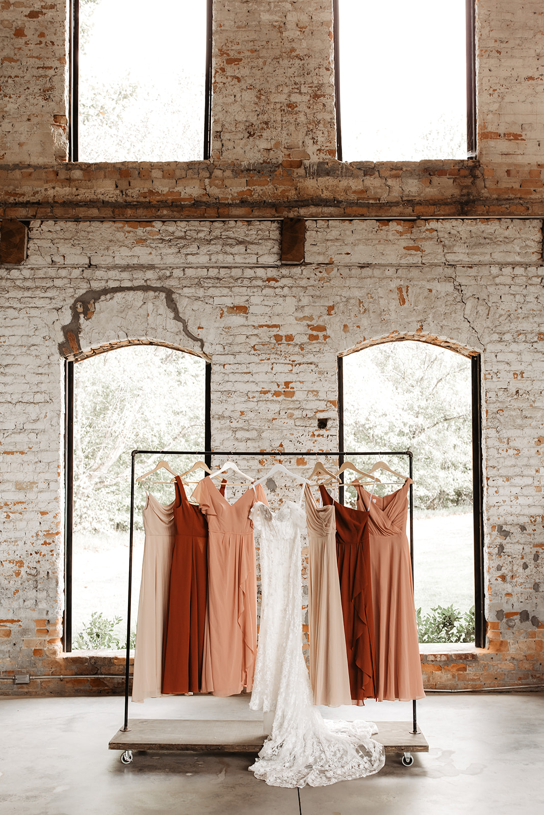 the bridesmaid dresses hanging in the doorway of the unique venue