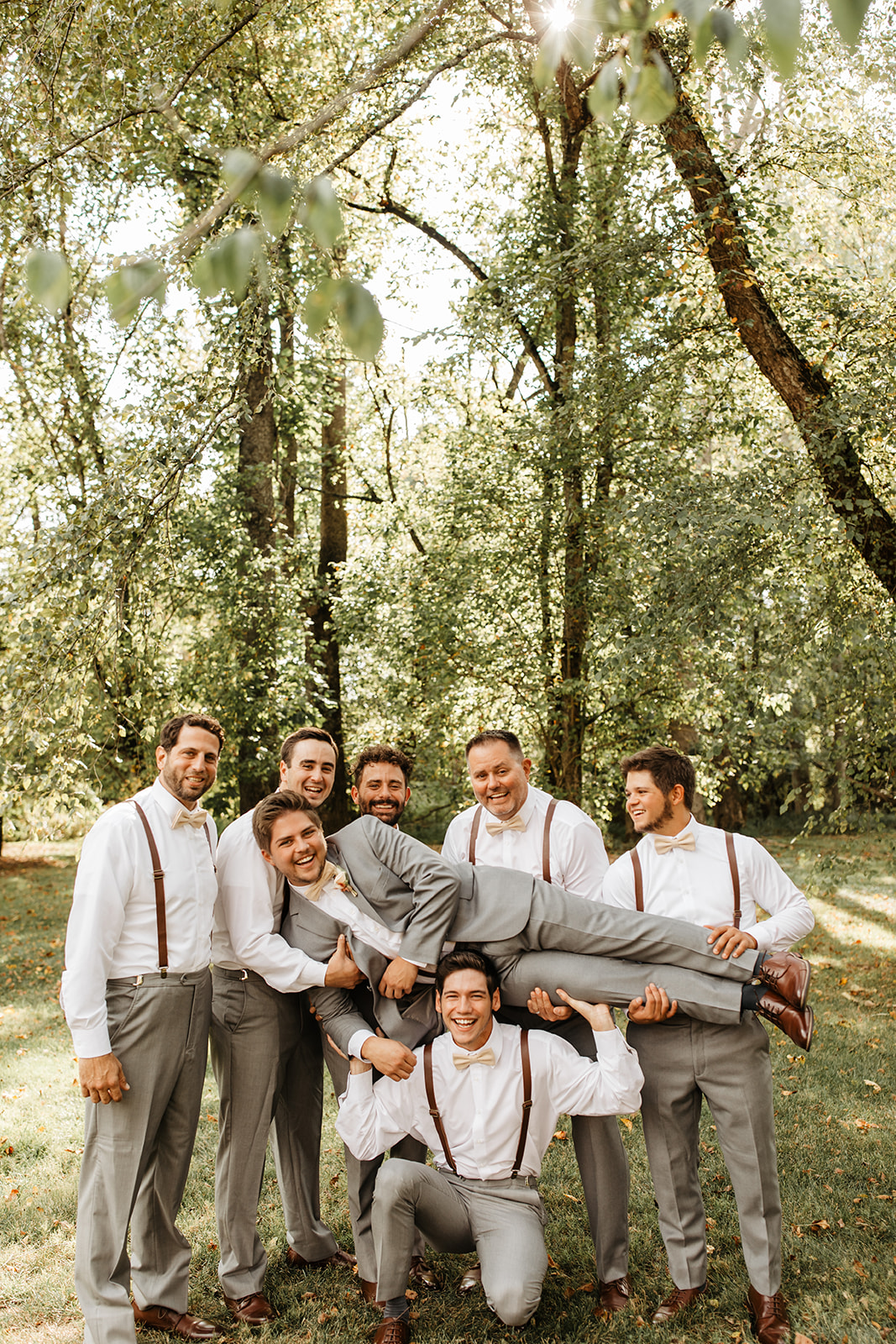the groomsmen lifting up the groom