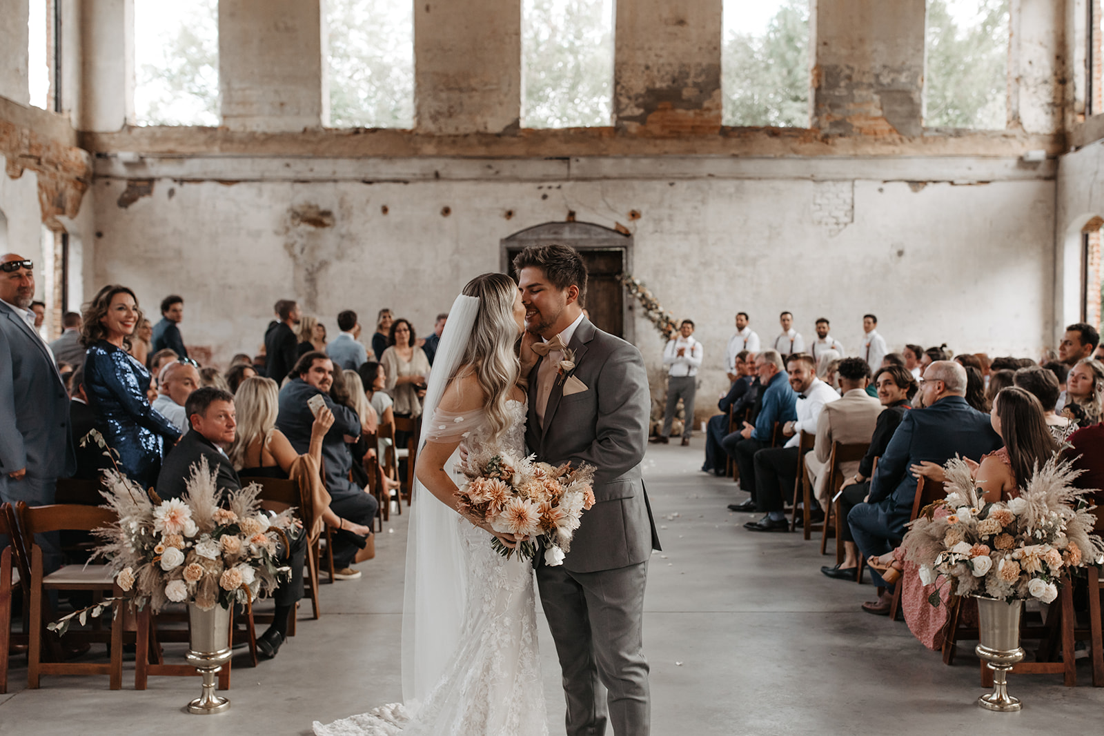 the couple kissing at the end of the aisle as husband and wife