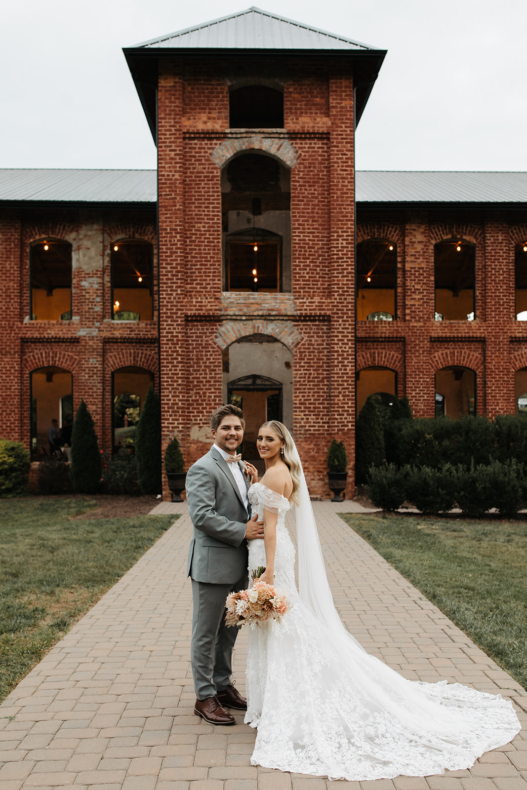 the couple standing in front of their unique wedding venue
