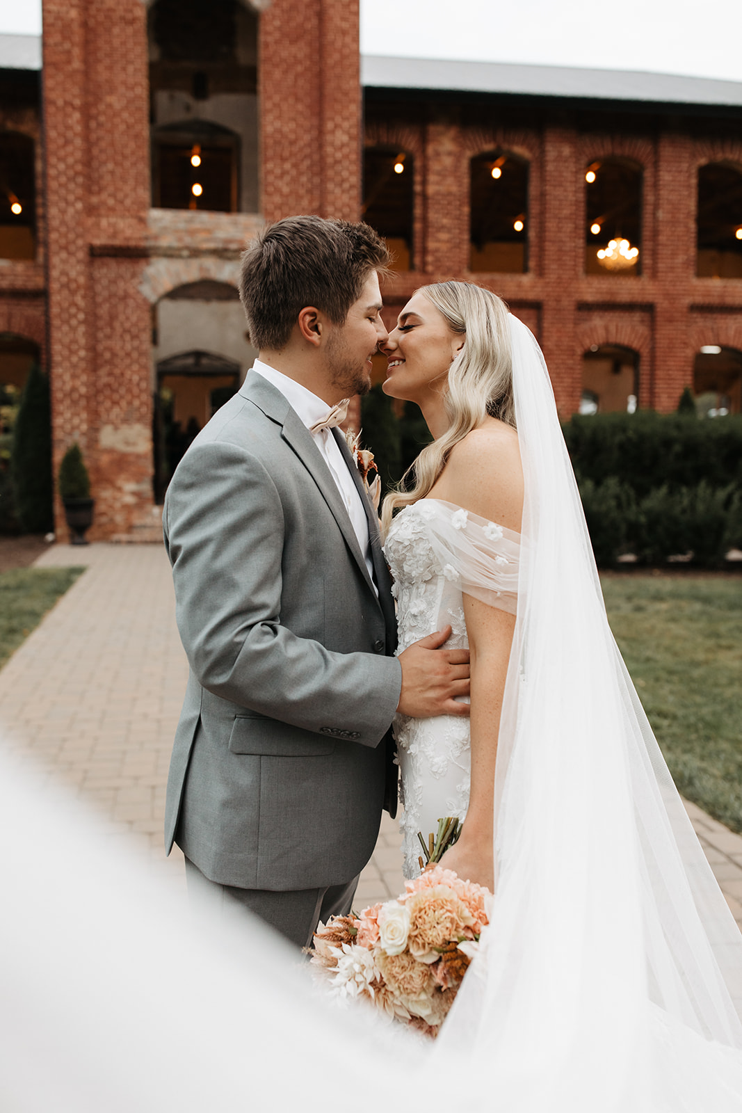 the couple kissing in front of the unique wedding venue