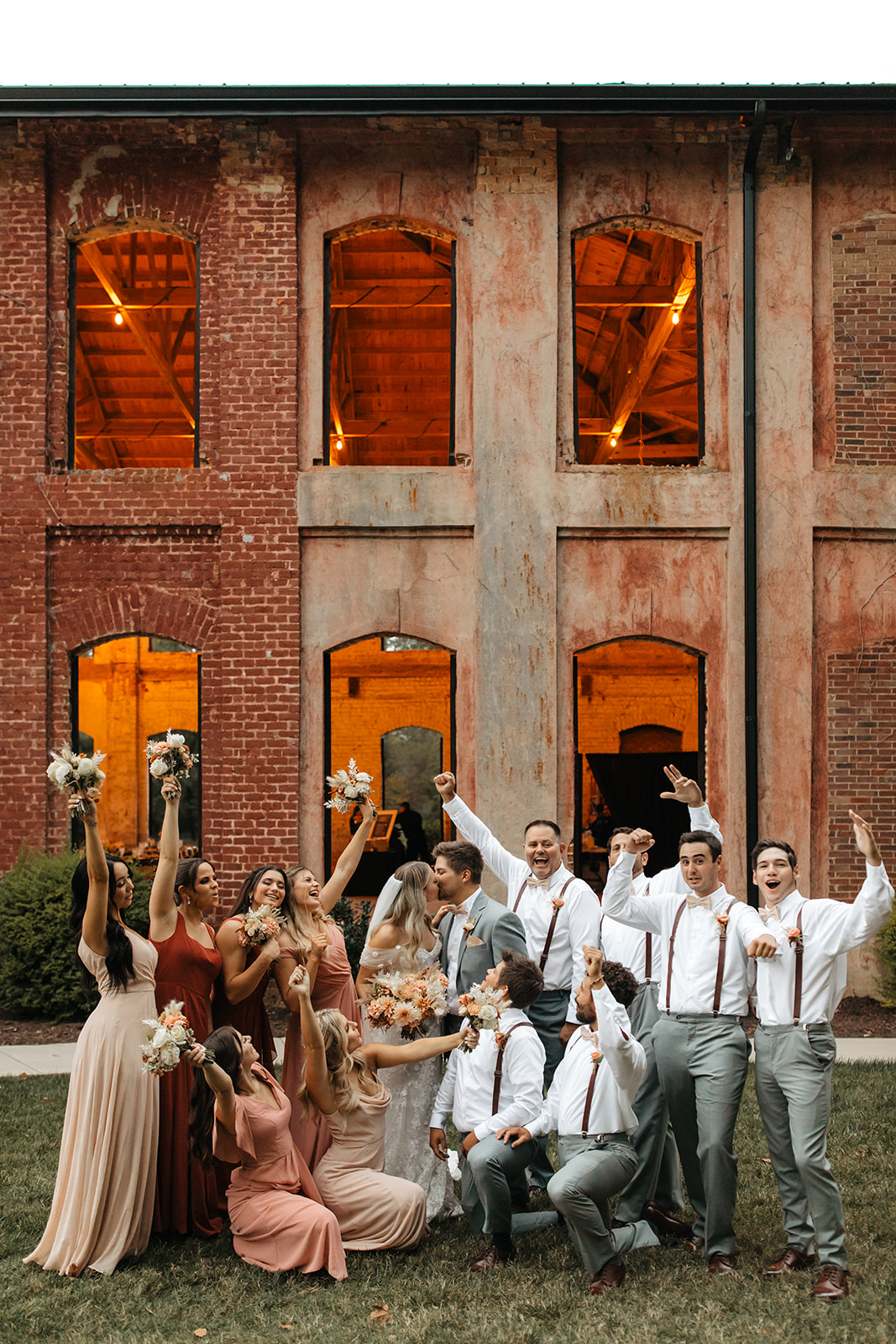 the bridal party celebrating in front of the unique wedding venue