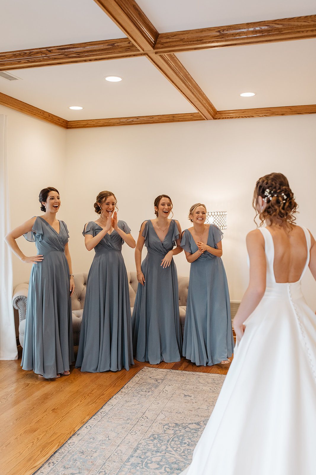 the bride showing her wedding dress to her bridesmaids