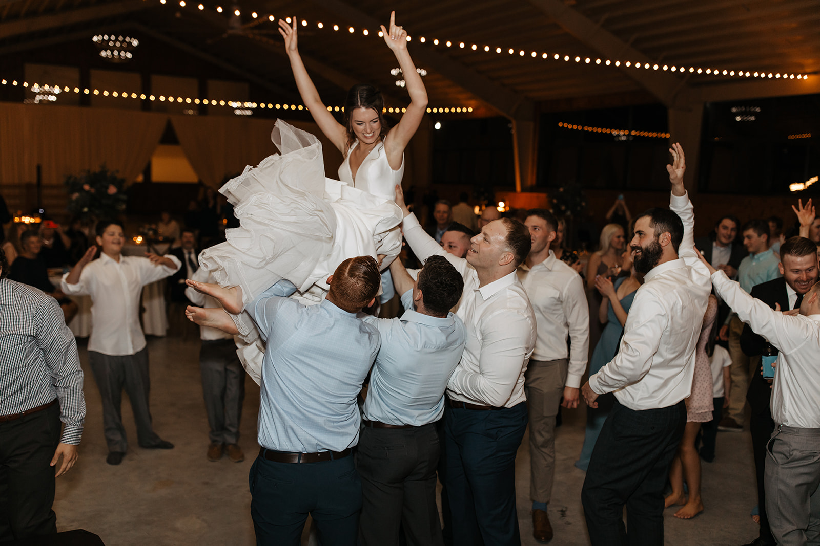 the bride getting lifted up by the party
