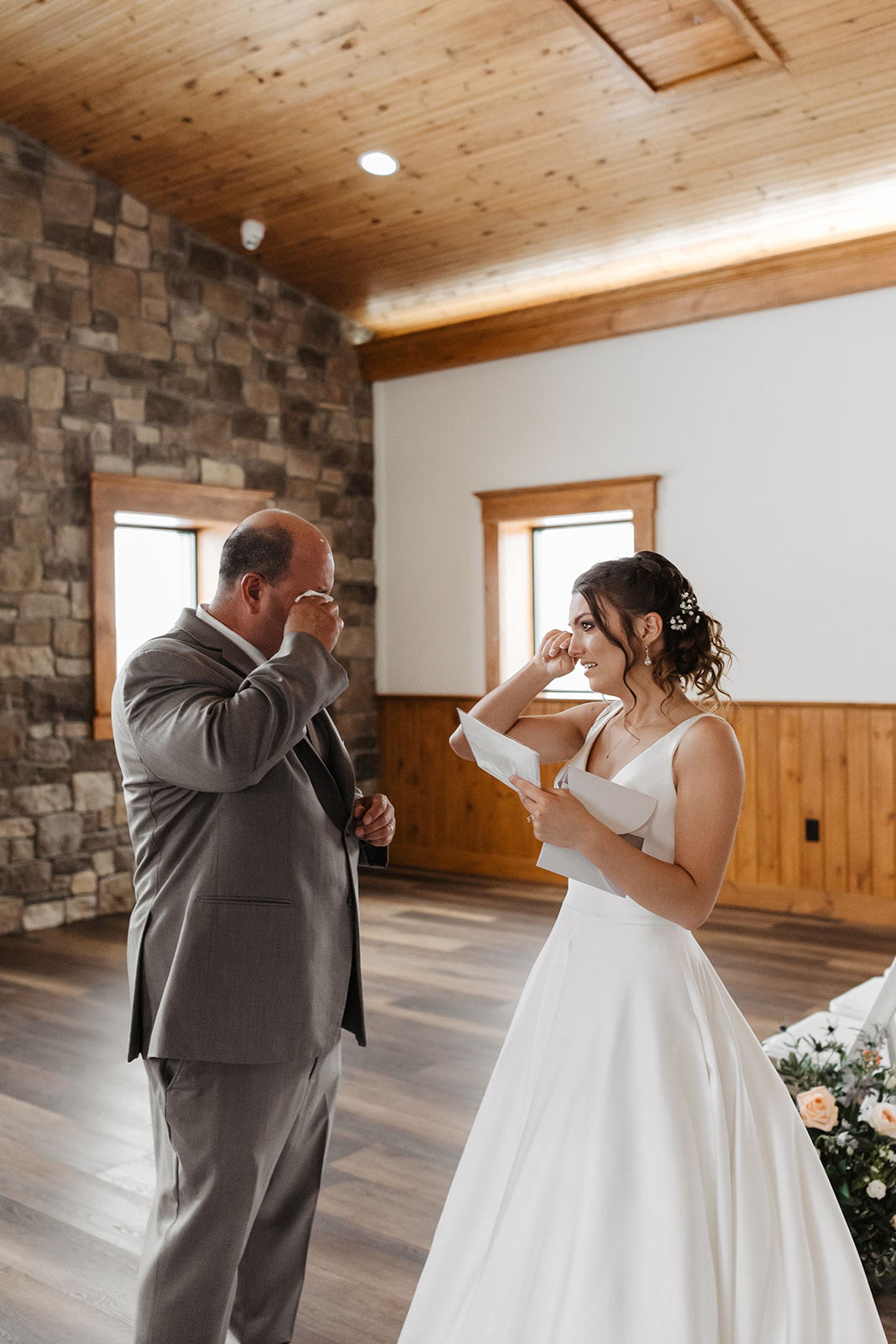 the bride and her dad wiping away tears after first look