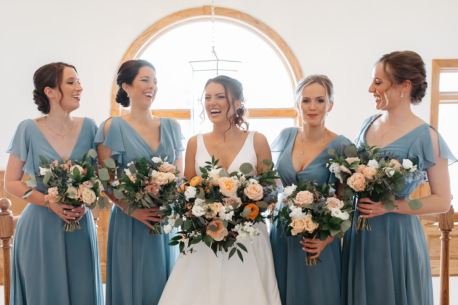 the bride with her bridesmaids laughing