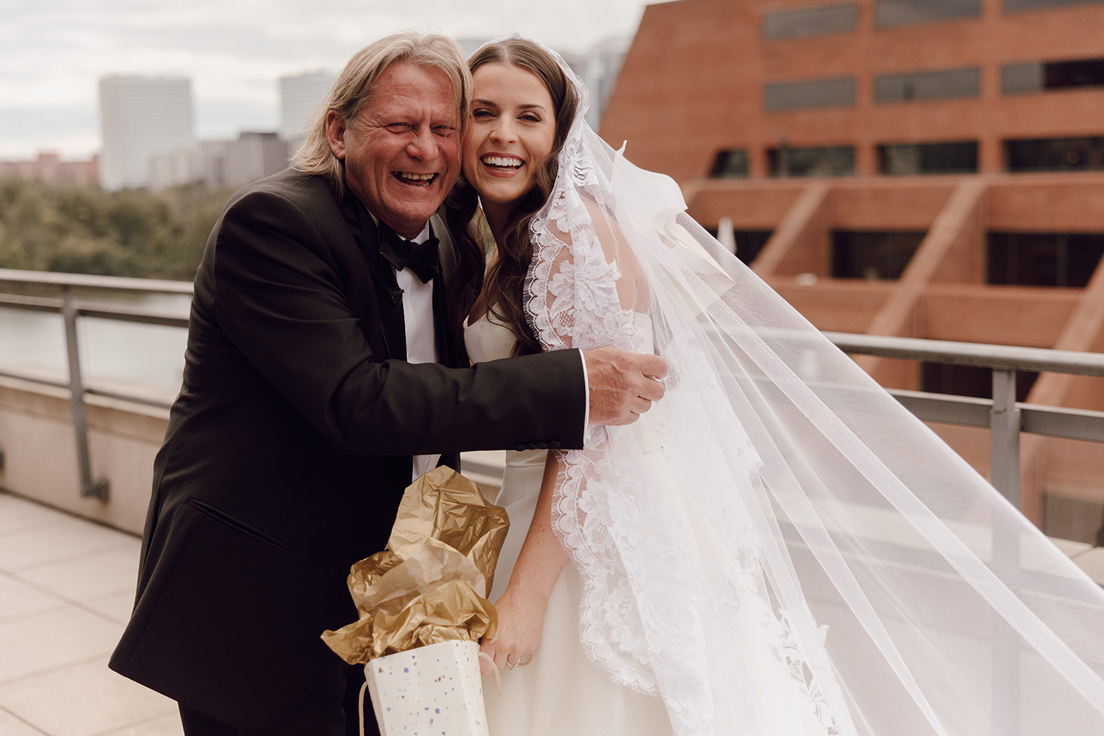 the bride laughing with her dad at their first look
