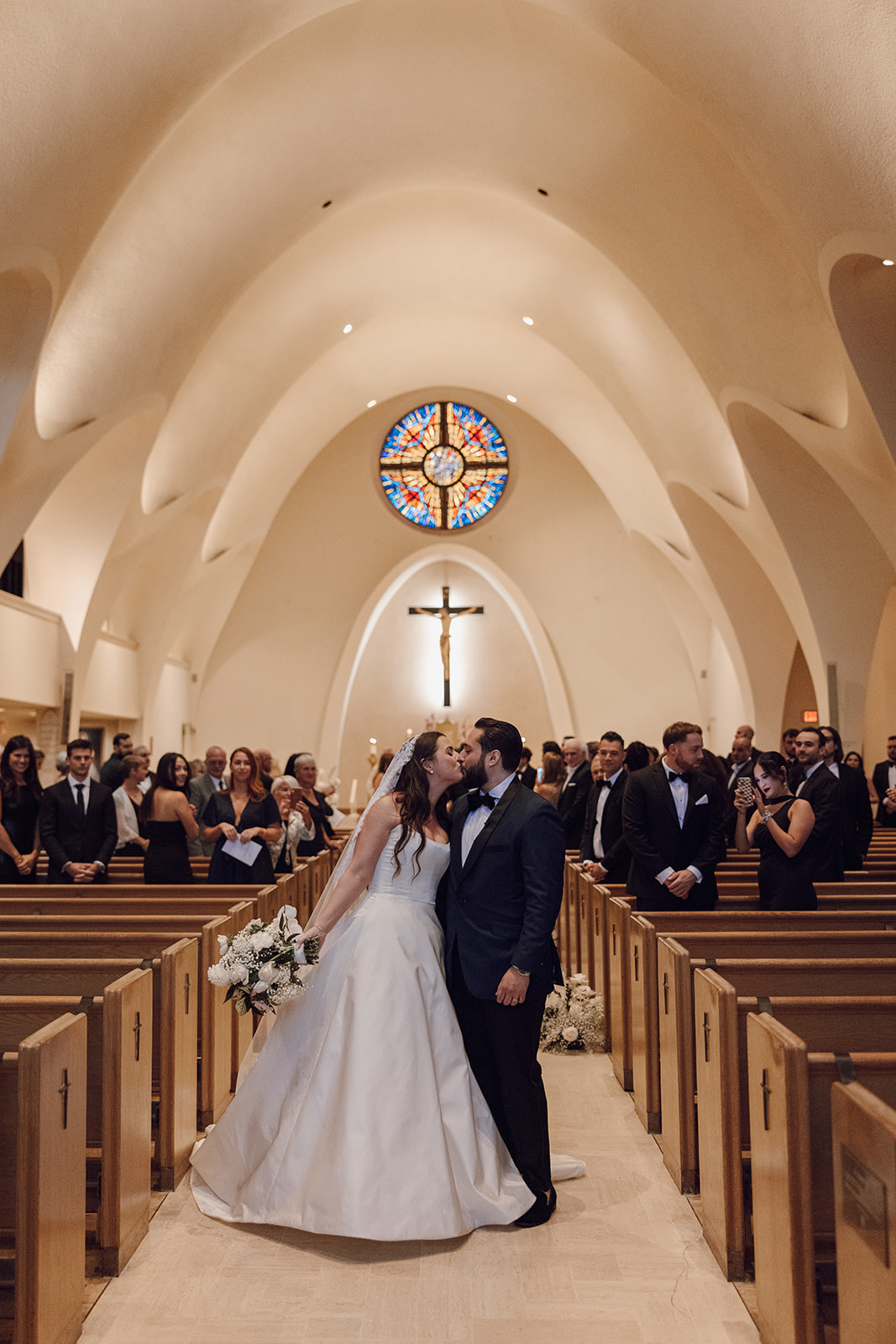 the couple kissing as husband and wife in the church in front of the wedding photographer in Washington DC