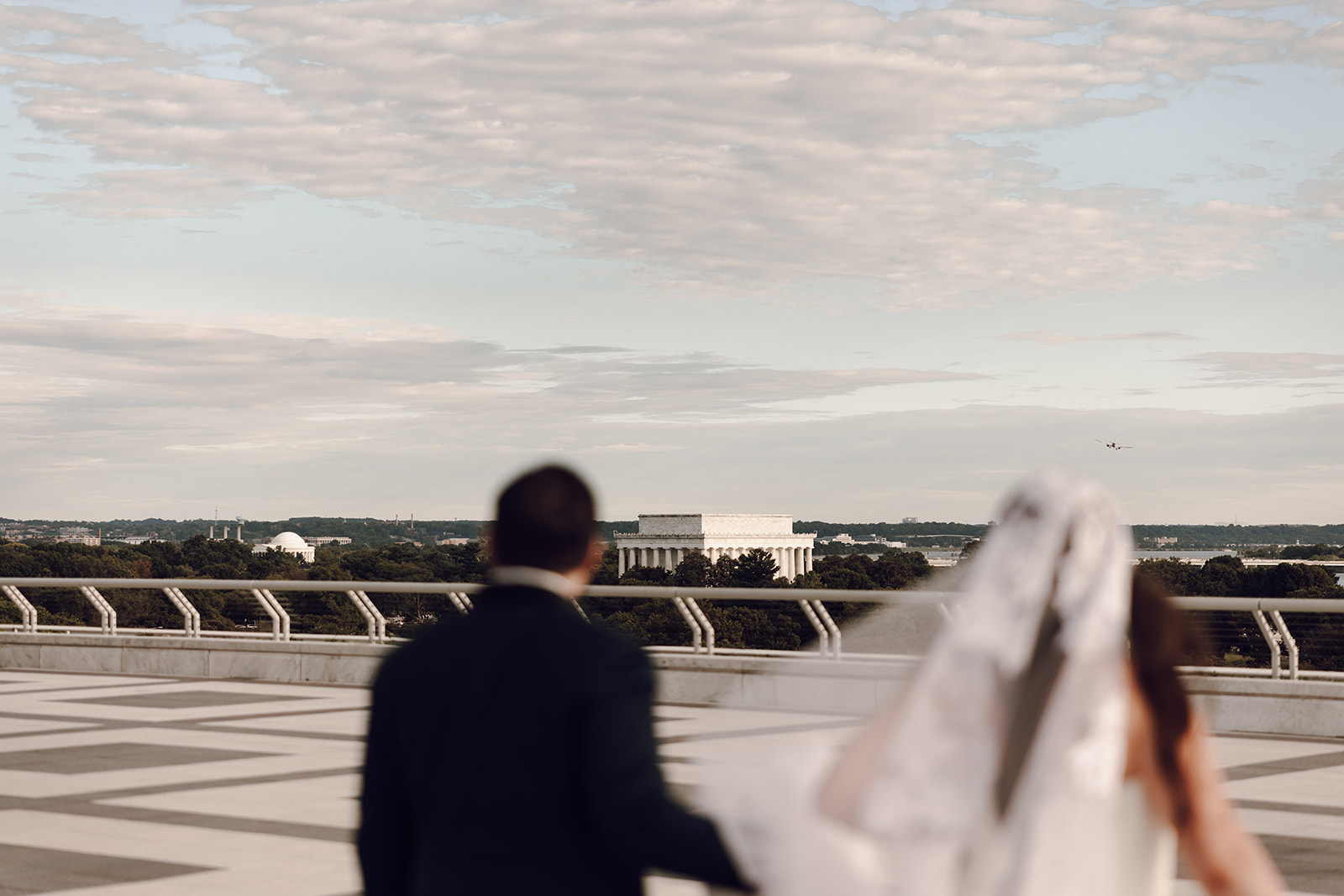 the couple walking towards the Kennedy Center captured by the wedding photographer in Washington DC