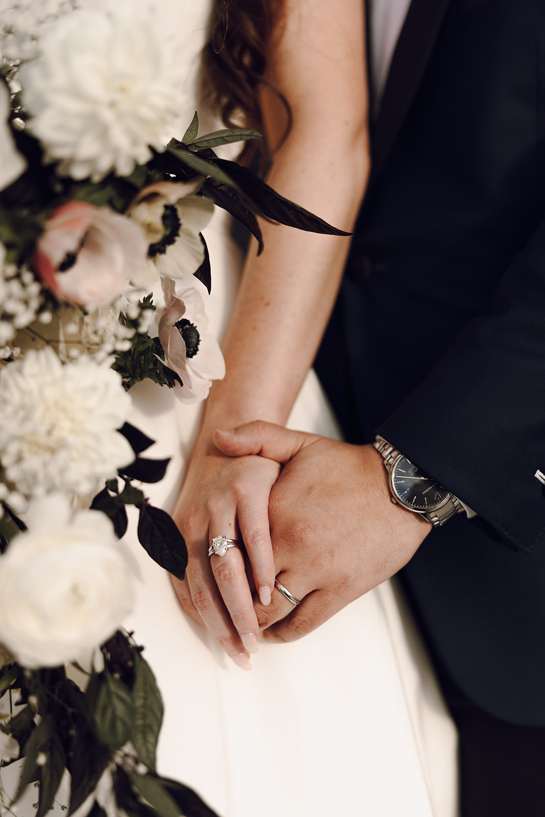 the couple holding hands with their wedding rings