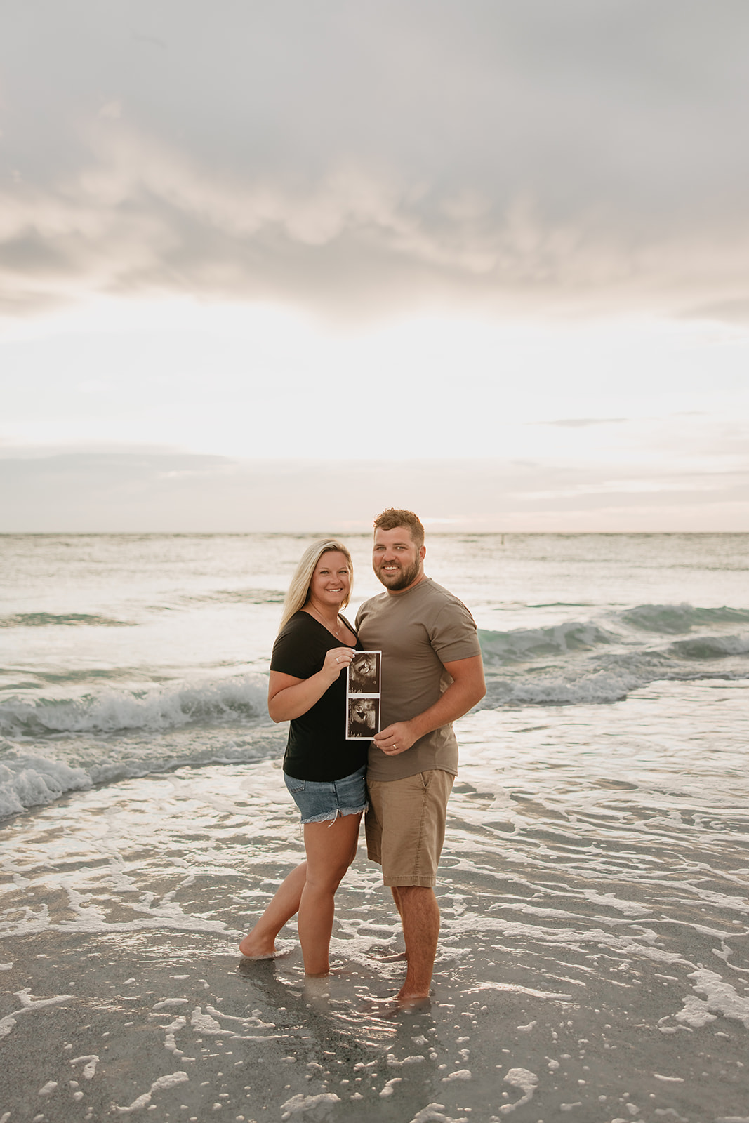 the couple standing in the water with their baby ultrasound photo