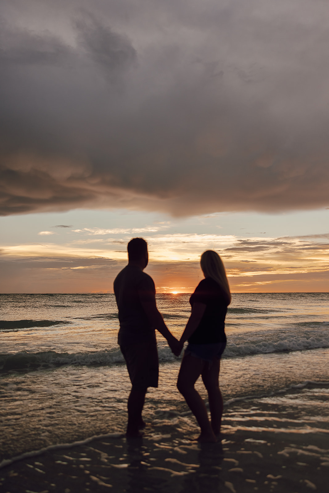 the couple standing in the sunset together