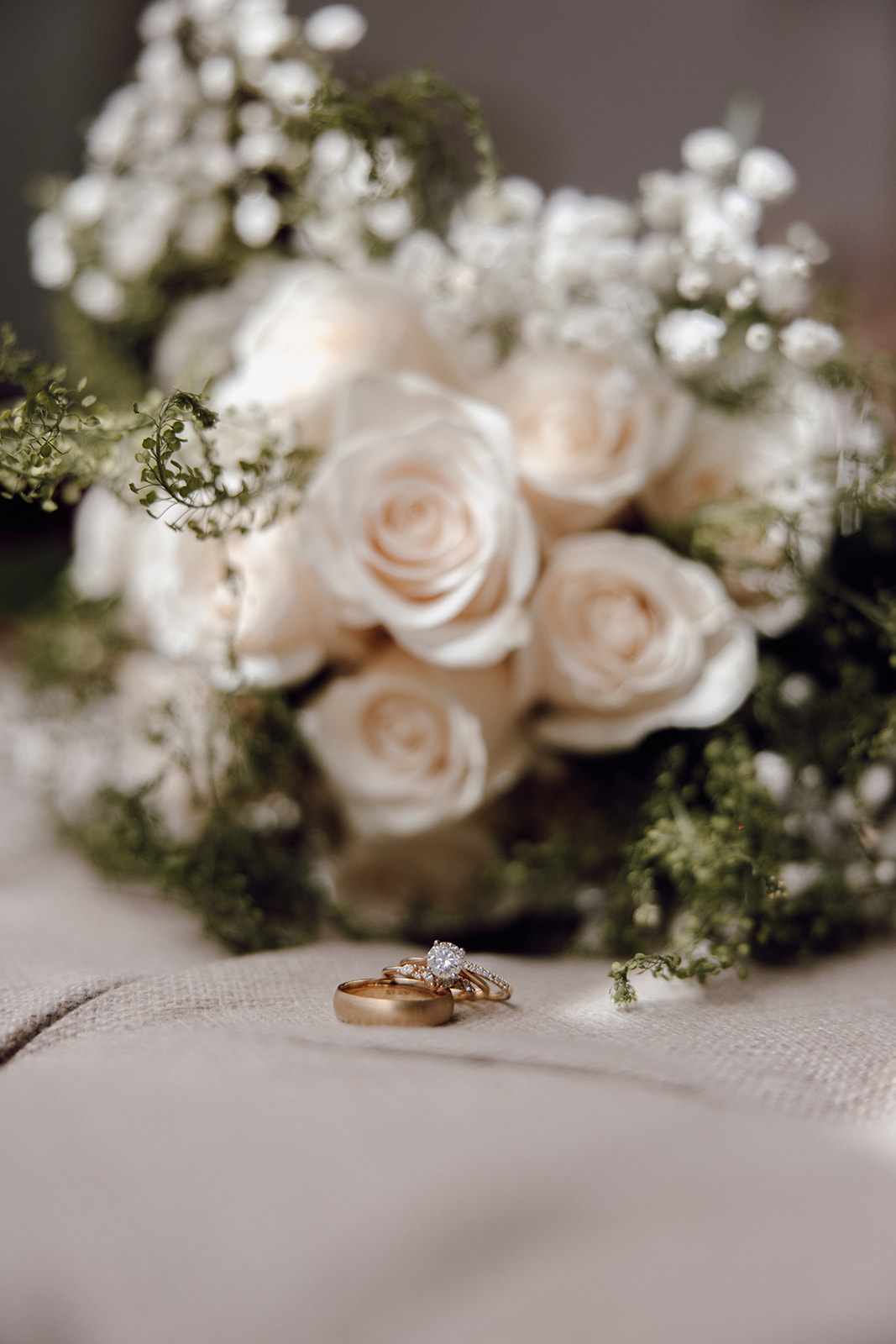 the wedding details with the white wedding bouquet and wedding rings