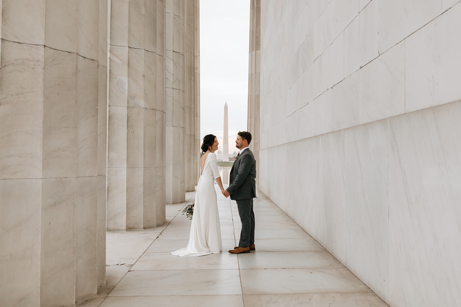 the couple holding hands at the Lincoln Memorial for their Hotel Wedding