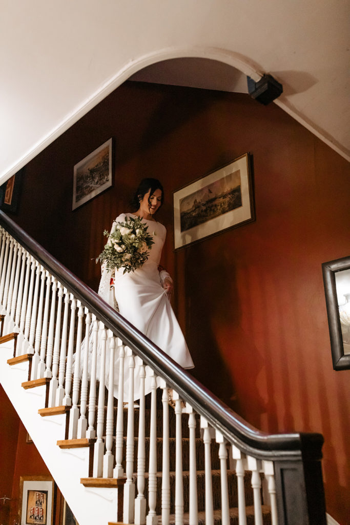 the bridal walking down the stairs after she gets ready at the hotel 