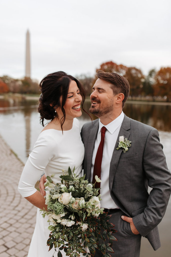 the couple laughing with one another during their wedding photos