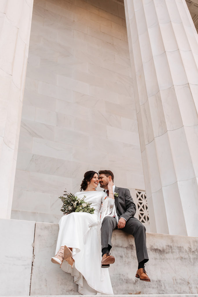 the couple leaning in for kiss at the Lincoln Memorial 