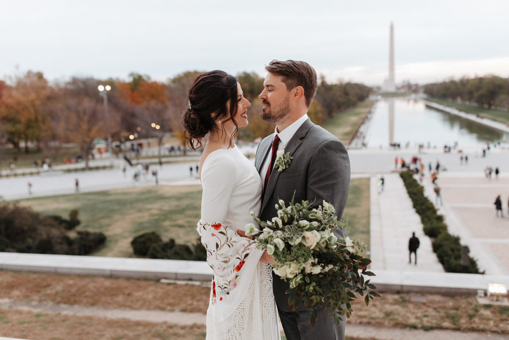 the couple looking at one another during wedding photos at the Lincoln Memorial
