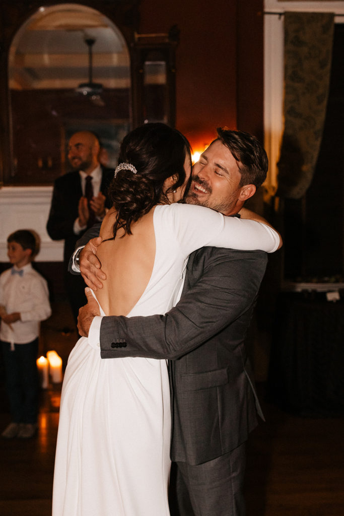the bride and groom hugging during their first dance