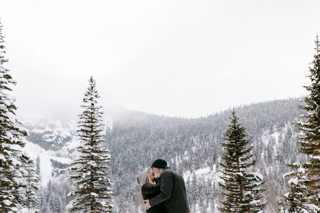 the couple kissing with the mountains in the background