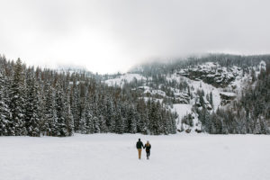 the couple walking in the snow together