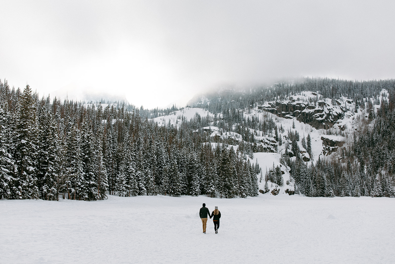 the couple walking in the snow together