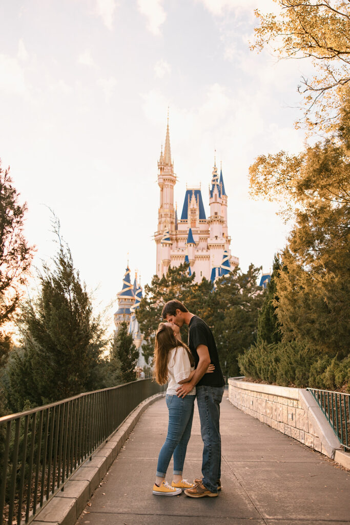 the couple kissing infront of the Cinderella Castle for their Magic Kingdom engagement photos