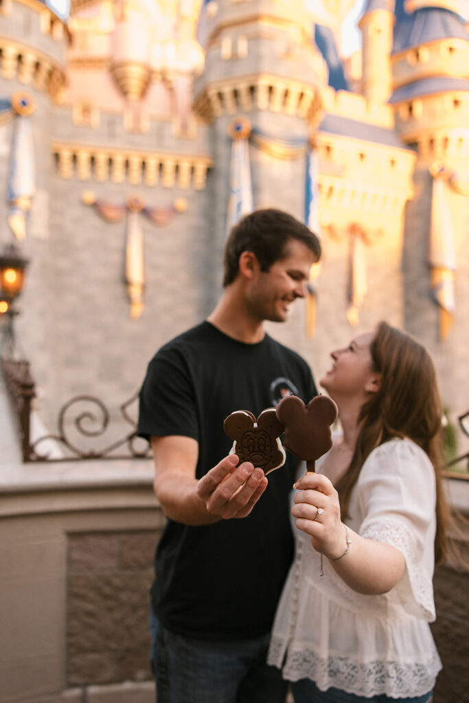 the couple smiling for engagement photos at the Magic Kingdom