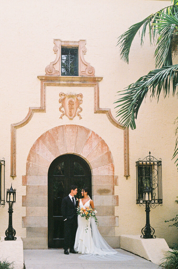 the bride and groom standing outside of the Florida wedding venue film photography 