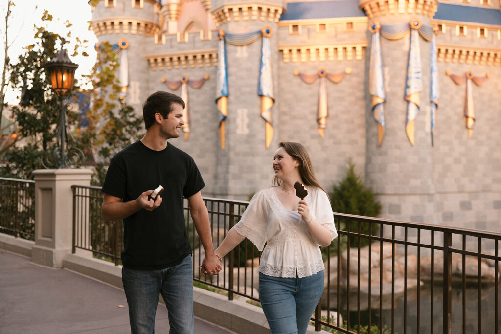 the engaged couple holding hands for their Disney Engagement Photos