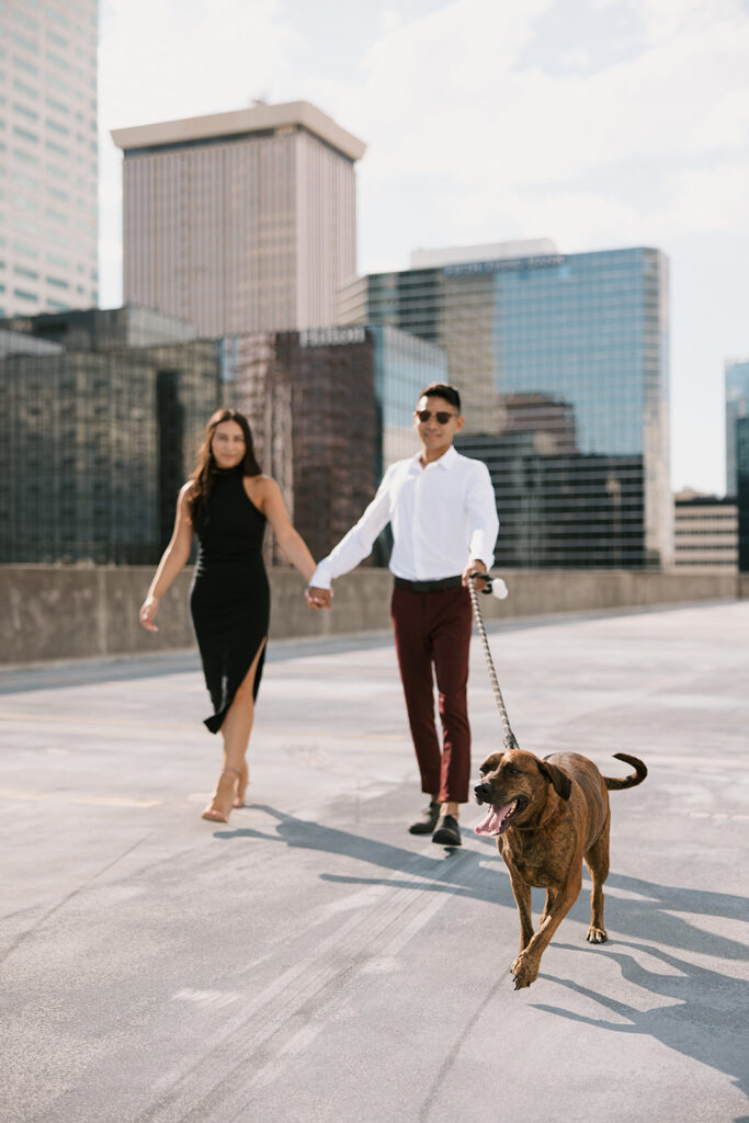 the engaged couple walking with their dog along the rooftop in Tampa