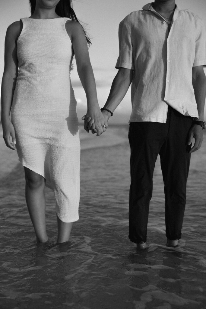 the engaged couple holding hands in the water at the beach in Tampa, Florida