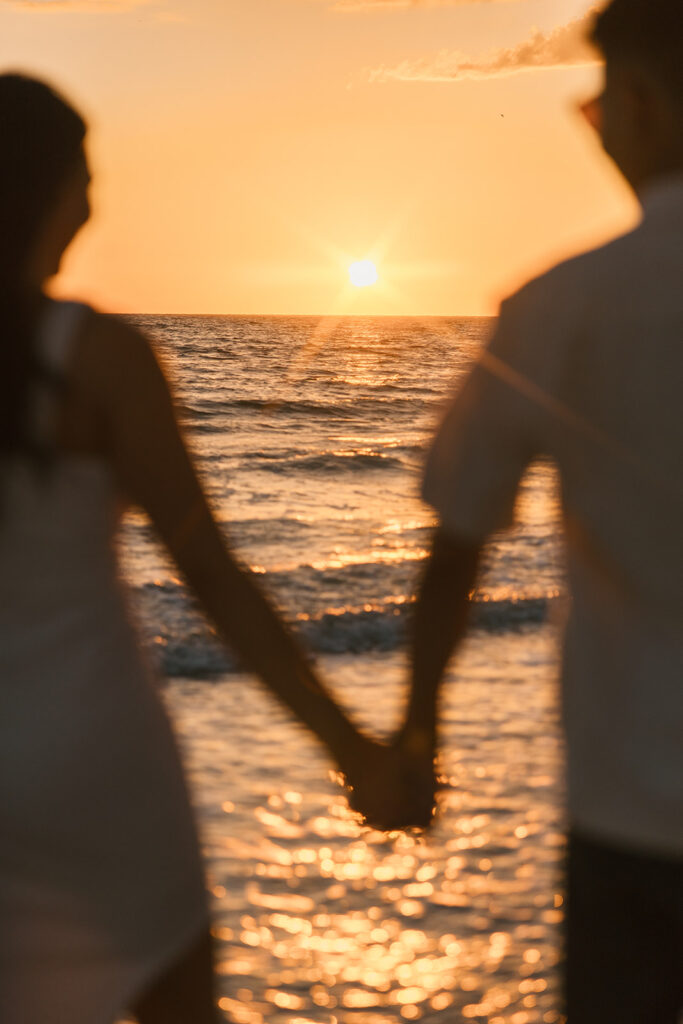 the engaged couple holding hands during the sunset in Tampa