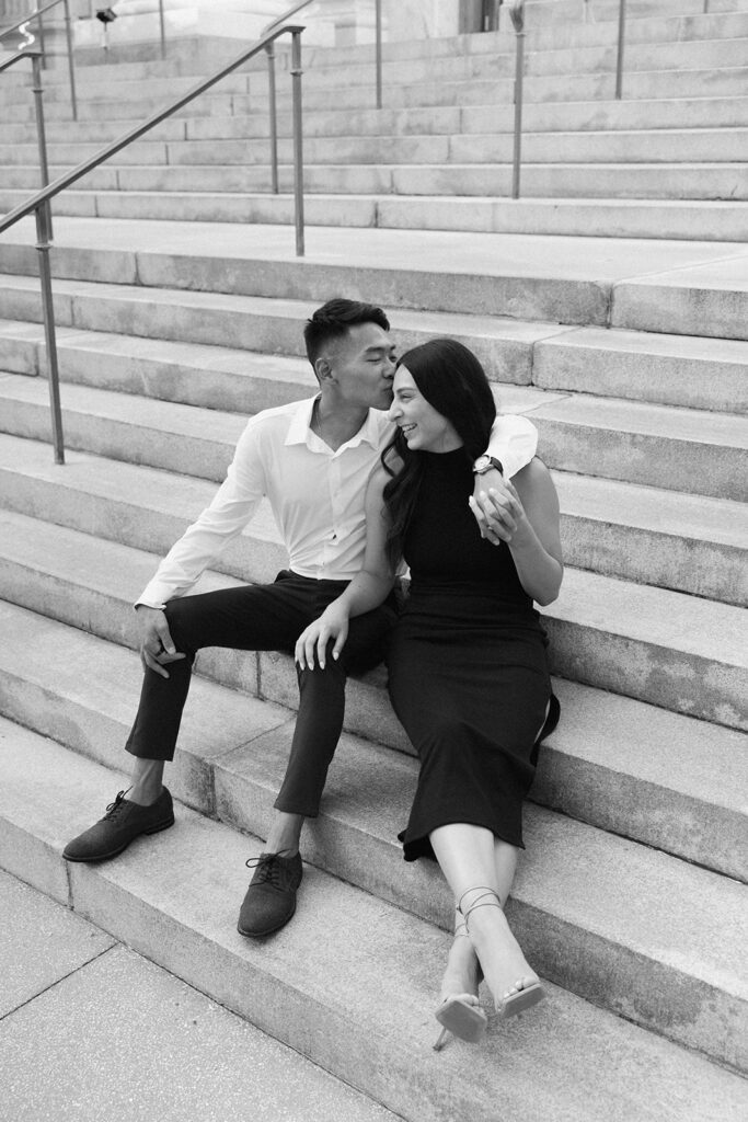 the engaged couple sitting on the stairs in downtown Tampa for engagement photos