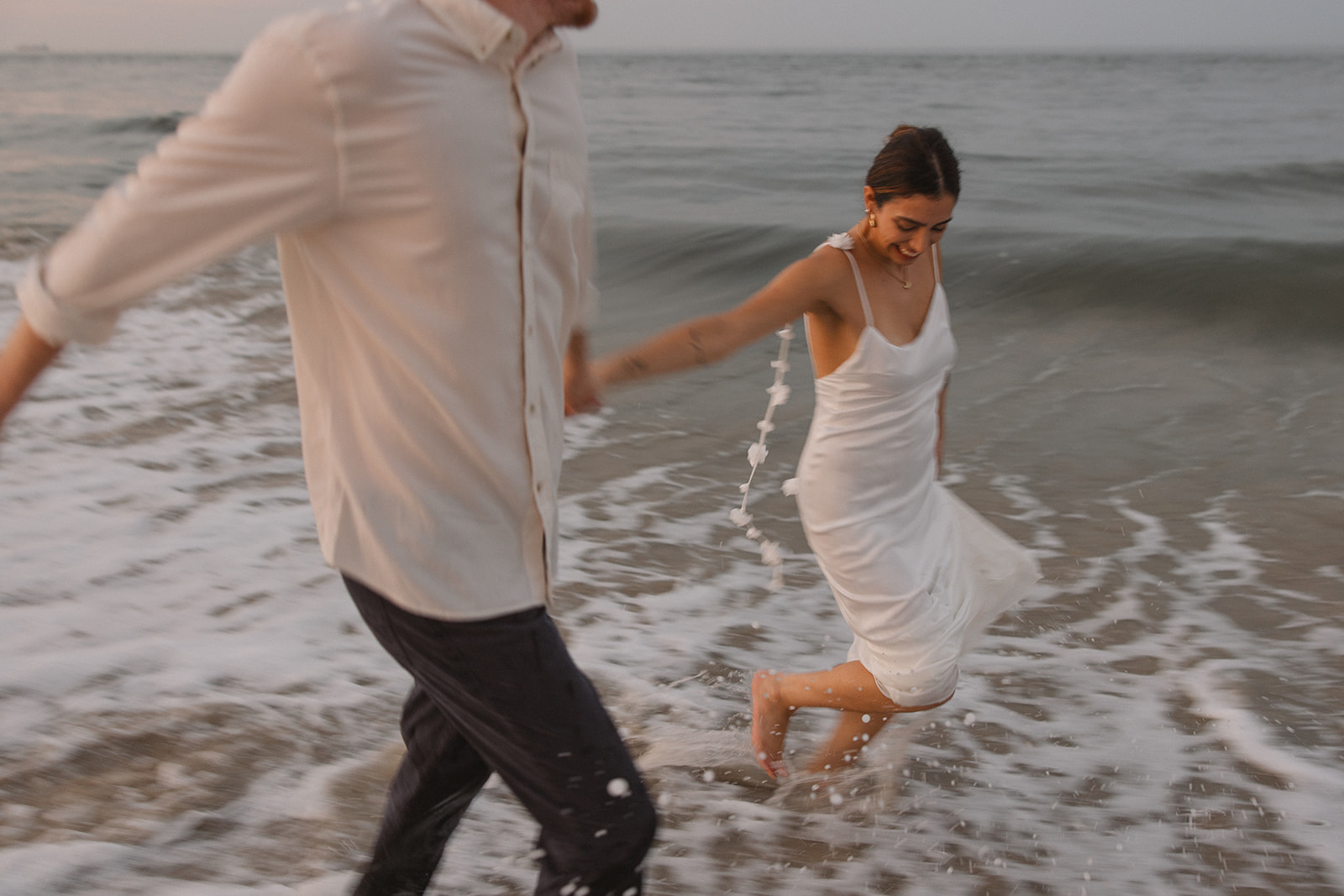 the couple running through the water on the east coast for beach engagement photos