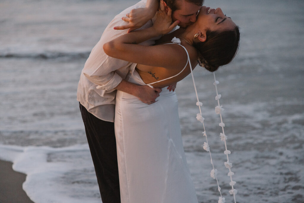 the engaged couple kissing in the water during their beach engagement photos on the east coast