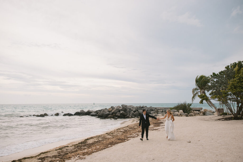 the bride and groom walking down the beach during their Key West elopement