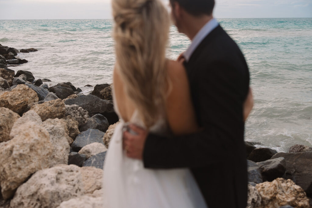 the bride and groom hugging one another on the beach in Key West