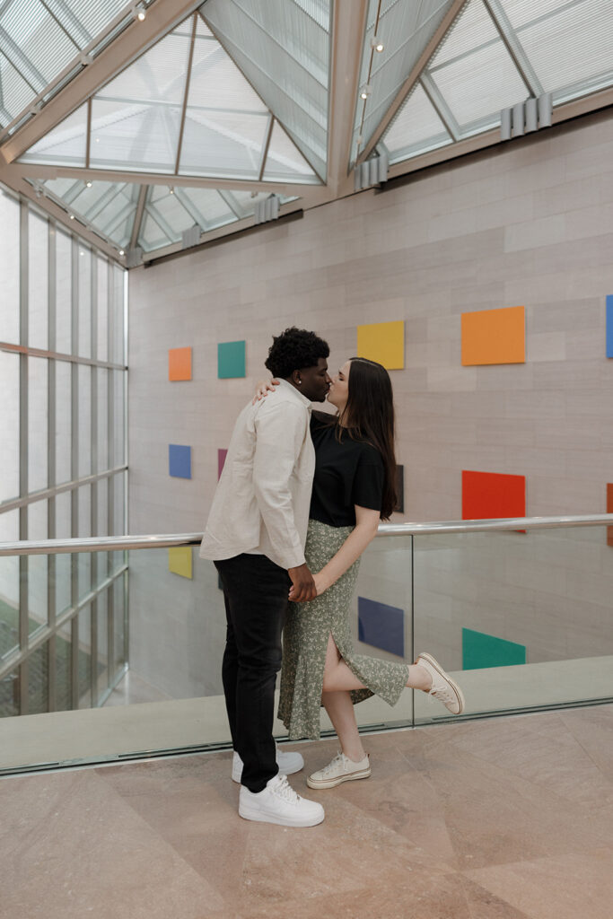 the engaged couple kissing at the art museum