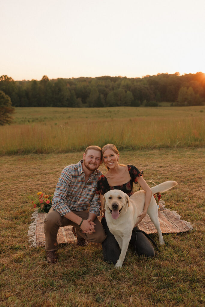 the engaged couple posing with their dog for proposal photos