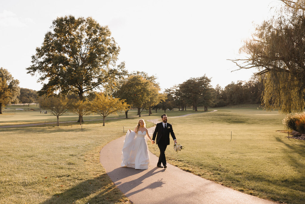 the wedding couple holding hands as they walk
