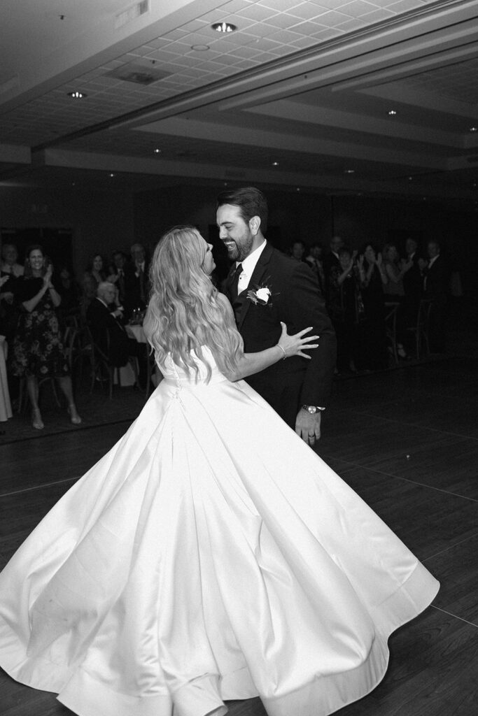 the bride and groom dancing at their wedding black and white photo